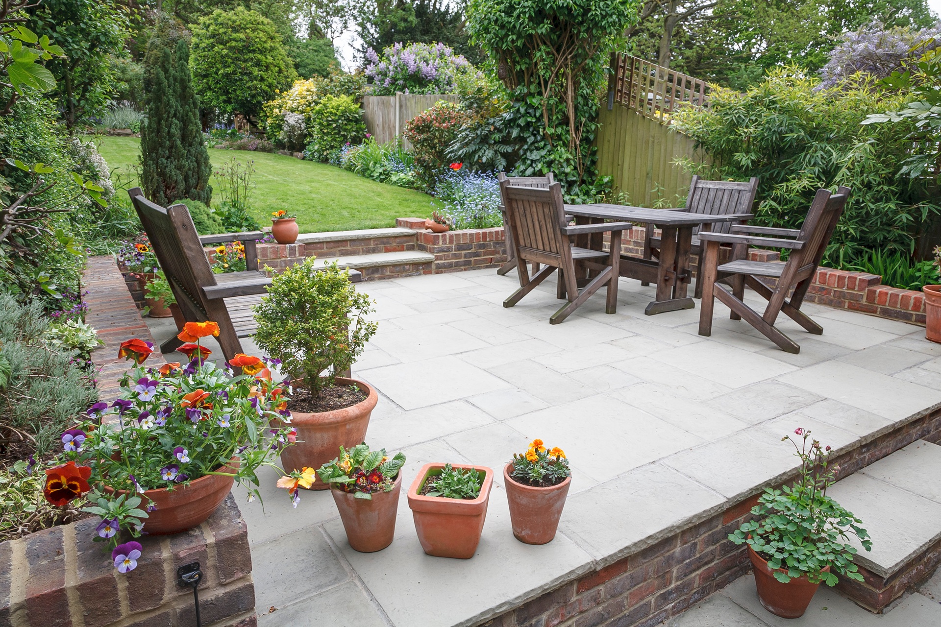 Terrasse mit Holzstühlen und Blumenkübeln | Terrassenüberdachung Berlin