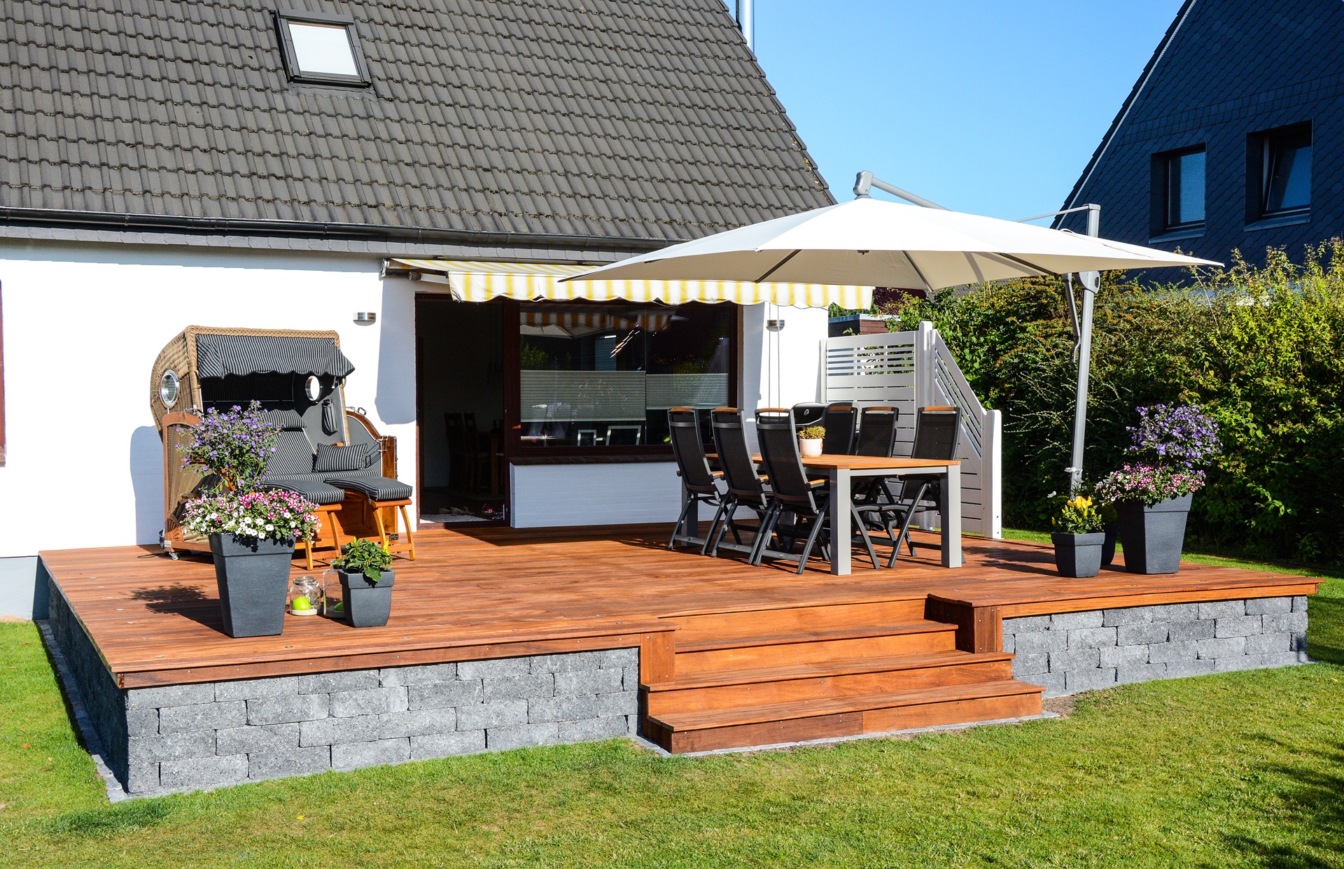 Terrasse mit Holzboden, Tisch und Sonnenschirm | Terrassenüberdachung Berlin